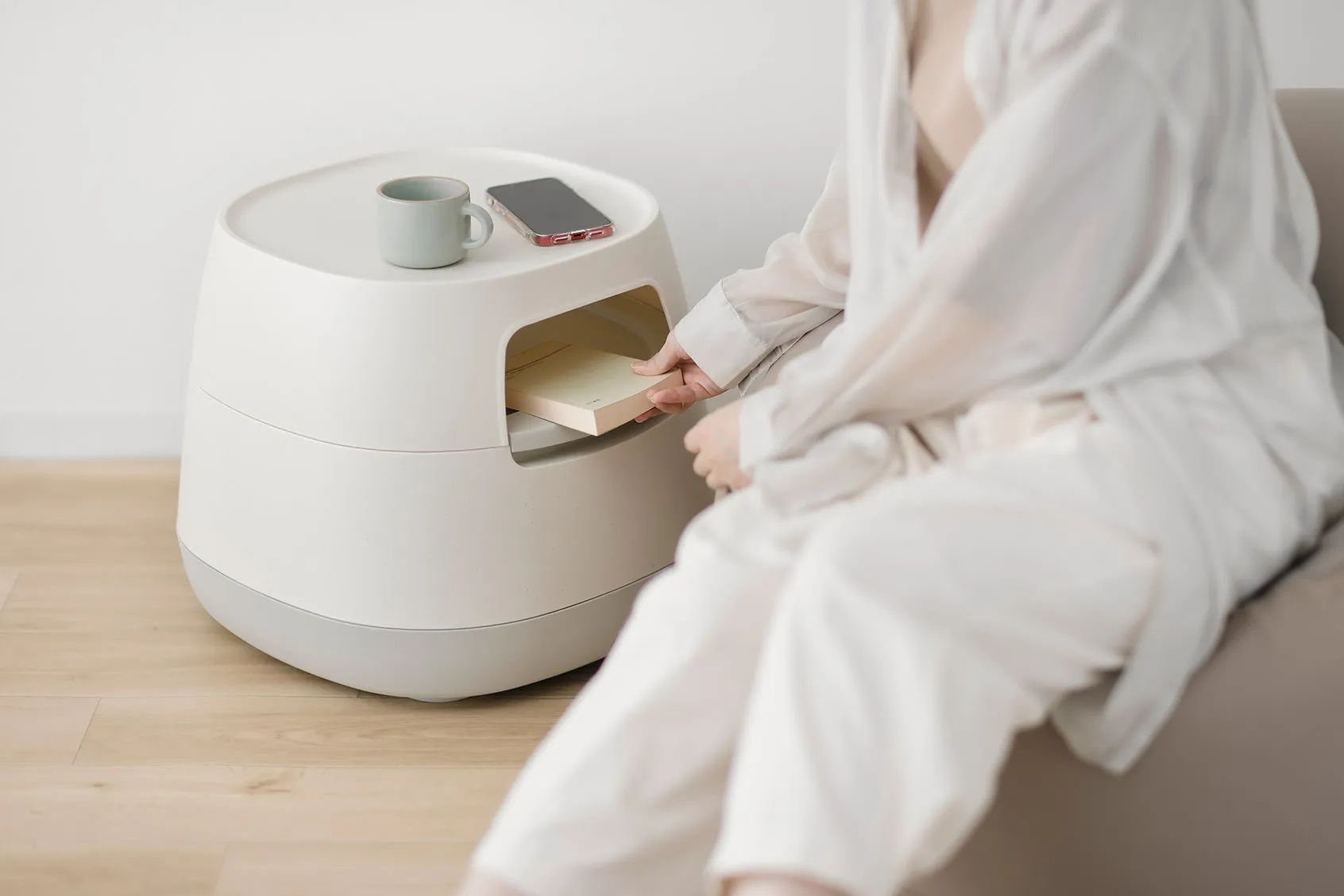 女性がサイドテーブルから本を取り出す画像