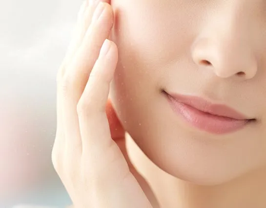 肌に触れる女性の手元と顔のクローズアップ