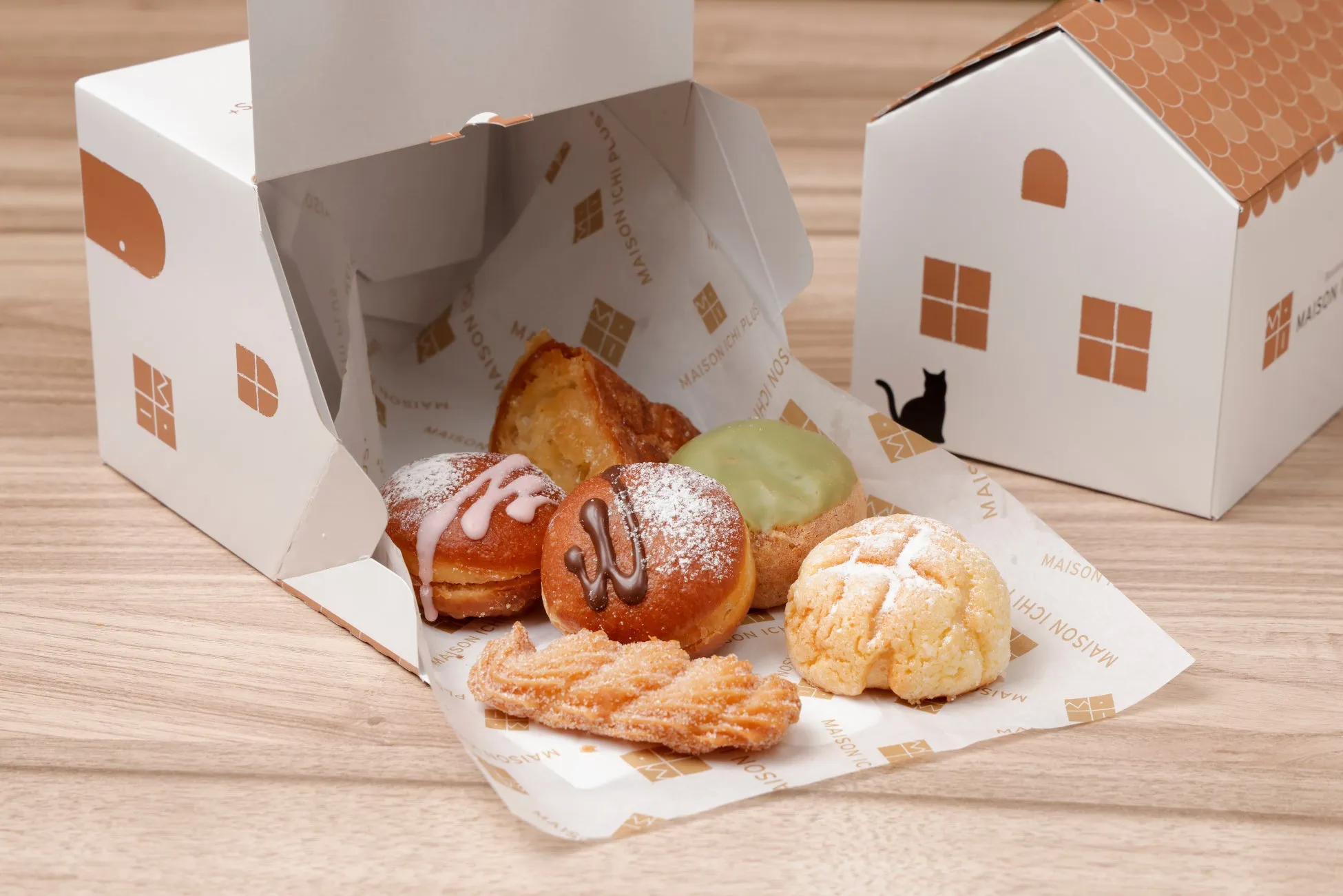 白い家型の箱に入った様々な種類のパンの集合写真。