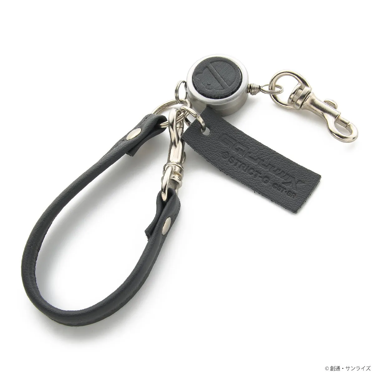 黒い革製のキーホルダー。キーホルダーは、黒い革のストラップ、リール、金属製の留め具で構成されています。リールには、STRICT-GとOST-GRのロゴが入った黒い革のタグが付いています。