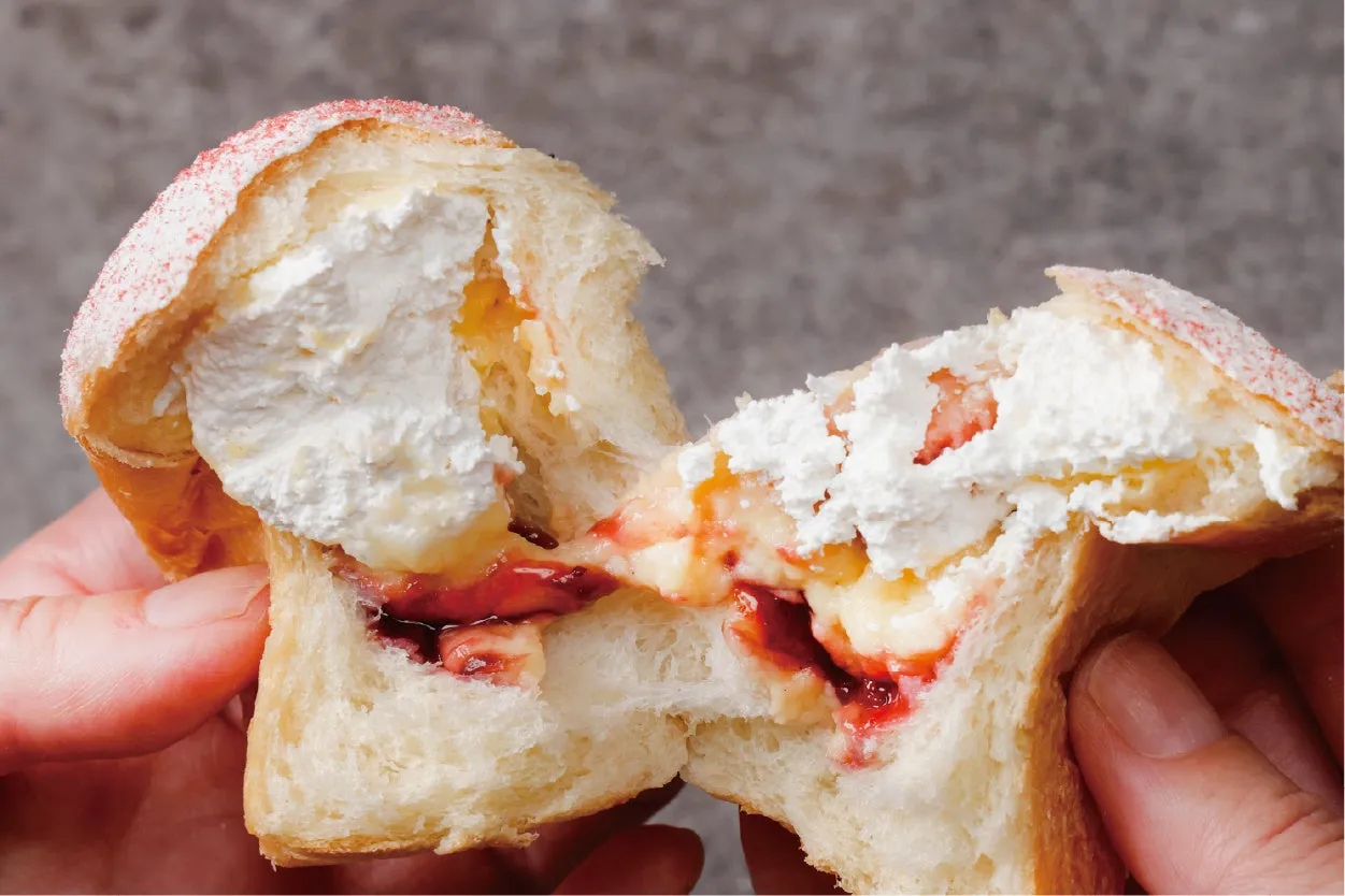 クリームとジャムがたっぷり詰まったパンの断面を写した写真。