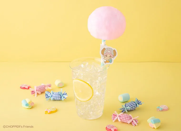 黄色い背景に、綿あめが乗ったストローが刺さった飲み物と、キャンディやマシュマロが散りばめられた写真。