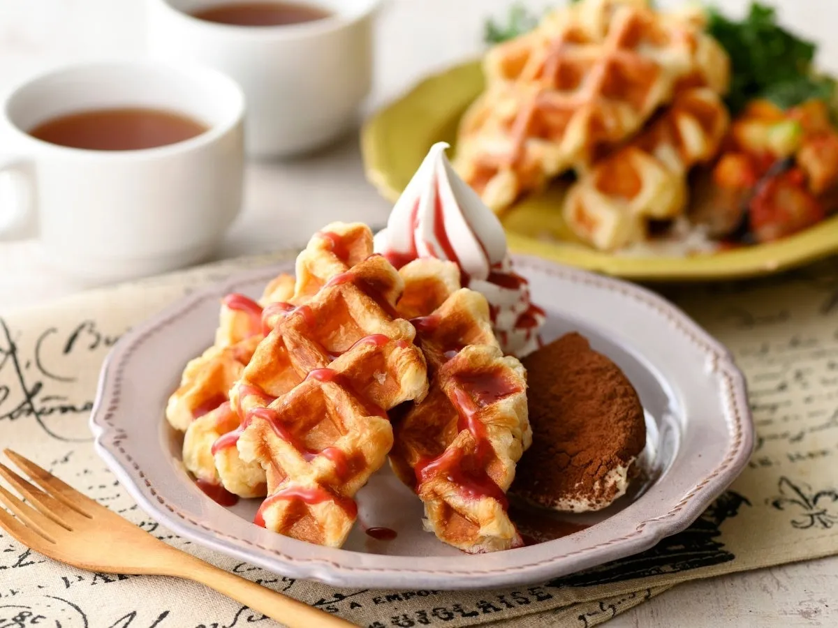 ワッフルとデザート、紅茶の入ったカップが写った写真。