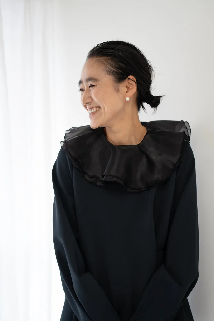 黒い服を着て微笑む女性のポートレート