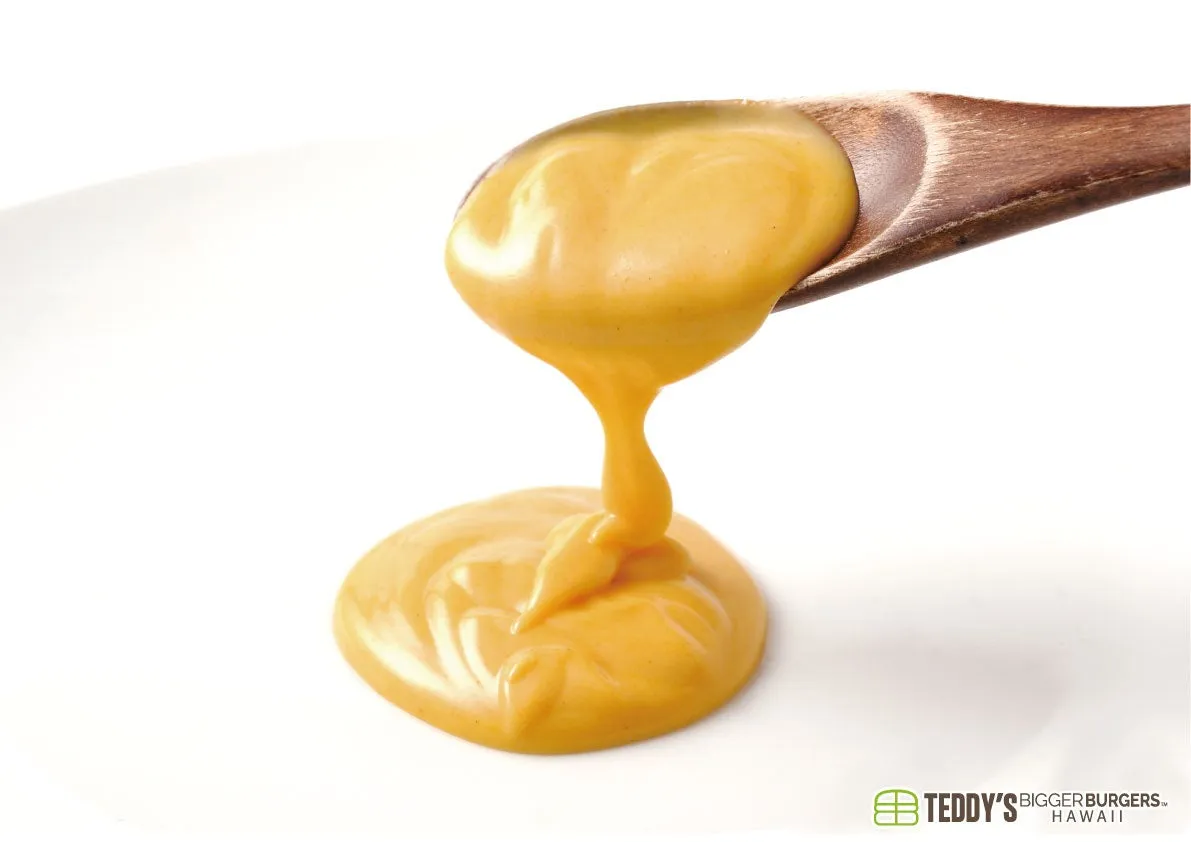 木製のスプーンからとろけるように流れ出る黄色のソース。