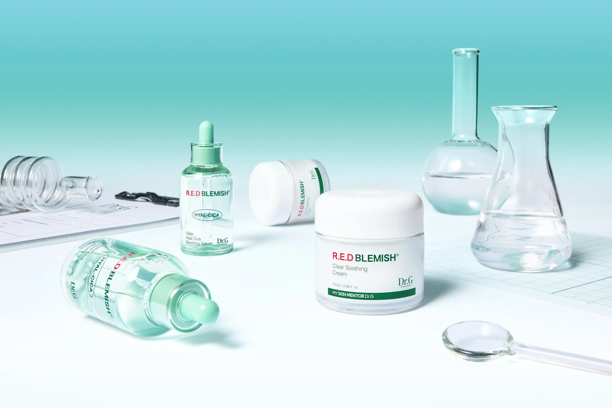 Dr.G製品と実験器具が並べられた写真。製品には「R.E.D BLEMISH」の文字が見え、美容に関するイメージを想起させる。