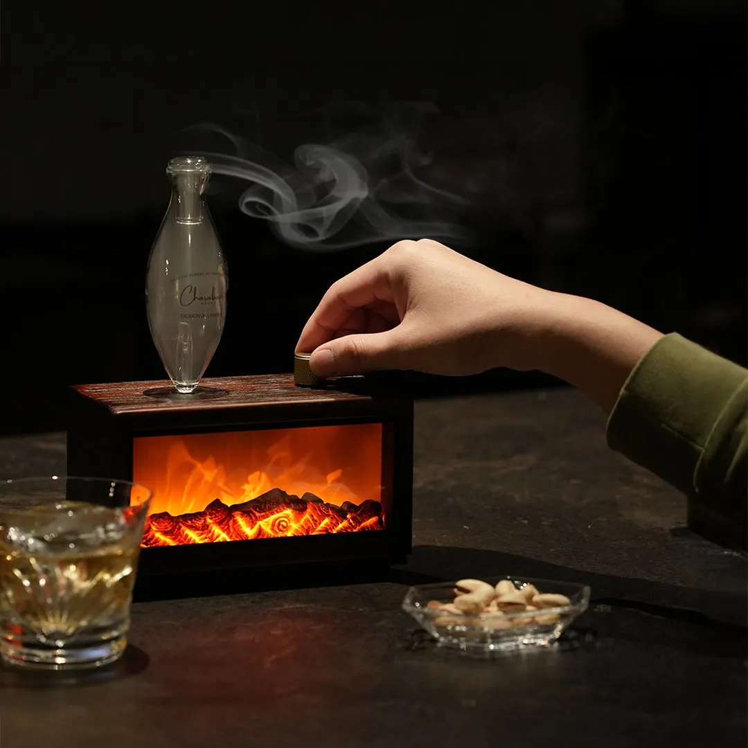 暖炉型の加湿器と、グラスに入った飲み物、ナッツの入った皿、人が加湿器を操作している様子が写っています。