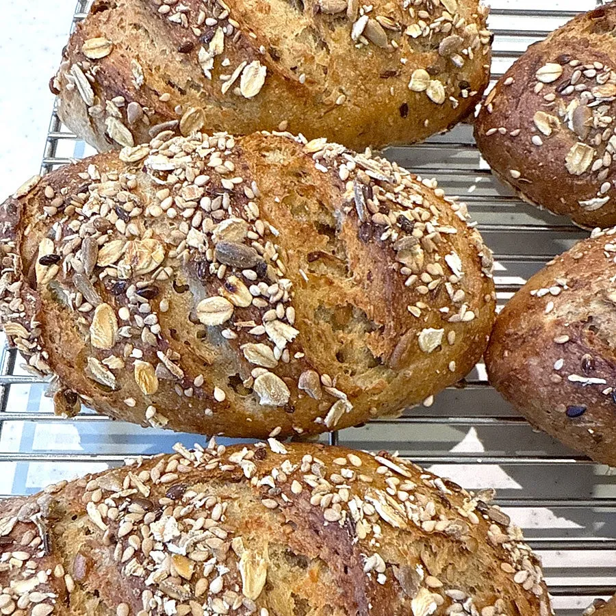 焼きあがったパンが網の上に並べられています。パンには、たくさんの穀物がトッピングされています。