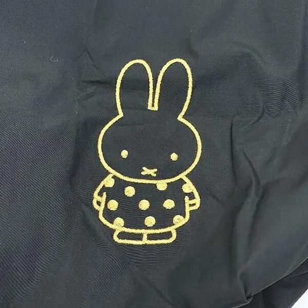 黒色の生地に、ミッフィーの刺繍が施された画像です。ミッフィーは黄色いアウトラインで描かれ、水玉模様の服を着ています。