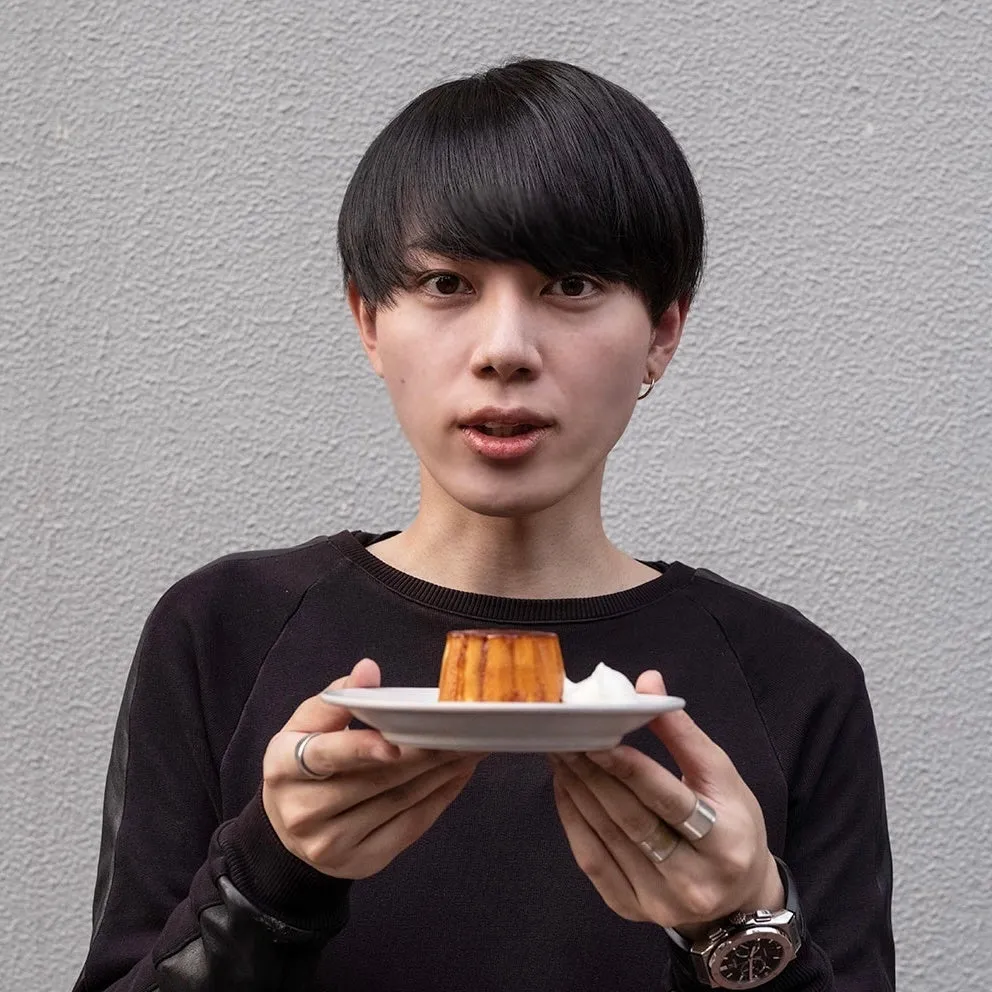 男性がプリンが乗ったお皿を持っている写真