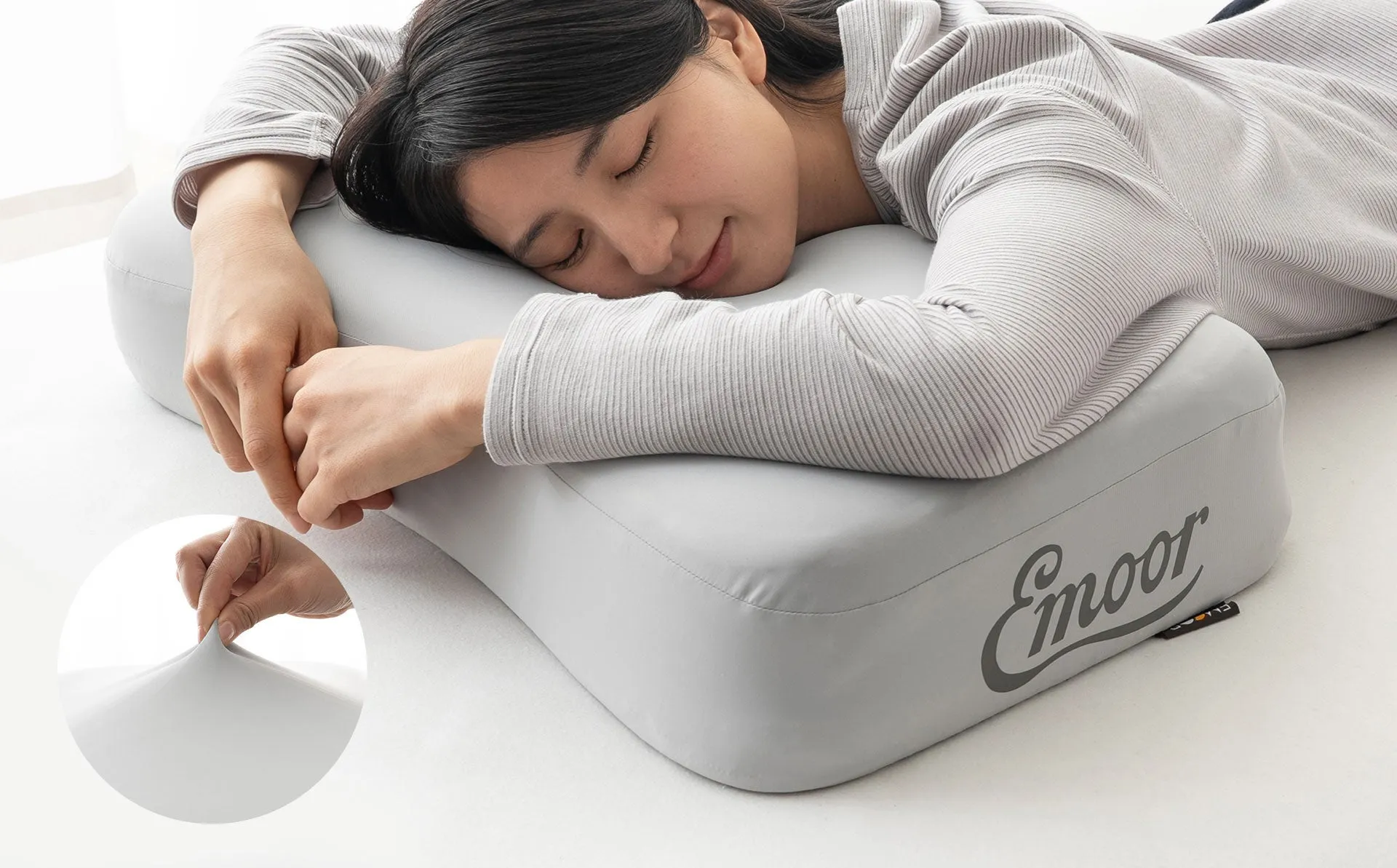 女性がEmoorの枕に寄り添って寝ている様子。