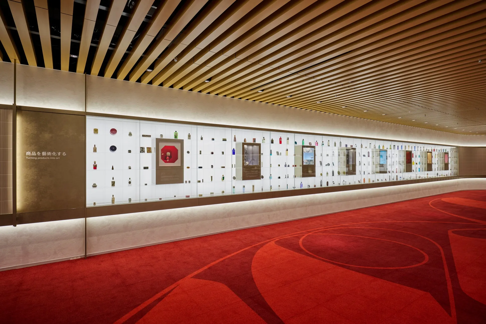 展示スペースのインテリア写真。壁には、さまざまな商品が陳列されたガラスケースが並び、それらを照らすように照明が設置されている。