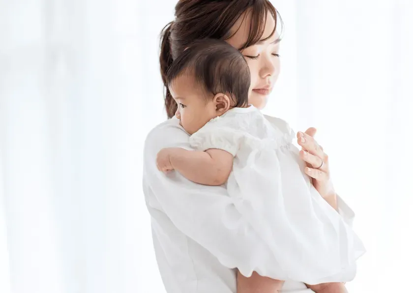 母親が赤ちゃんを抱っこしている写真