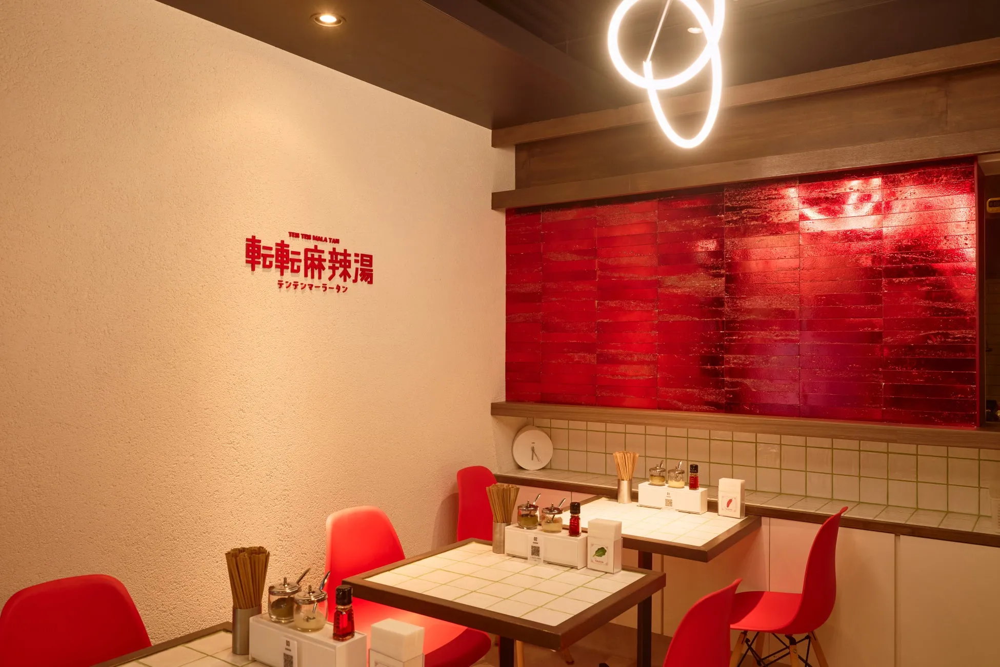 店内を写した写真。壁には「転転麻辣湯」の文字。テーブルと椅子は赤色で統一され、スタイリッシュな印象。