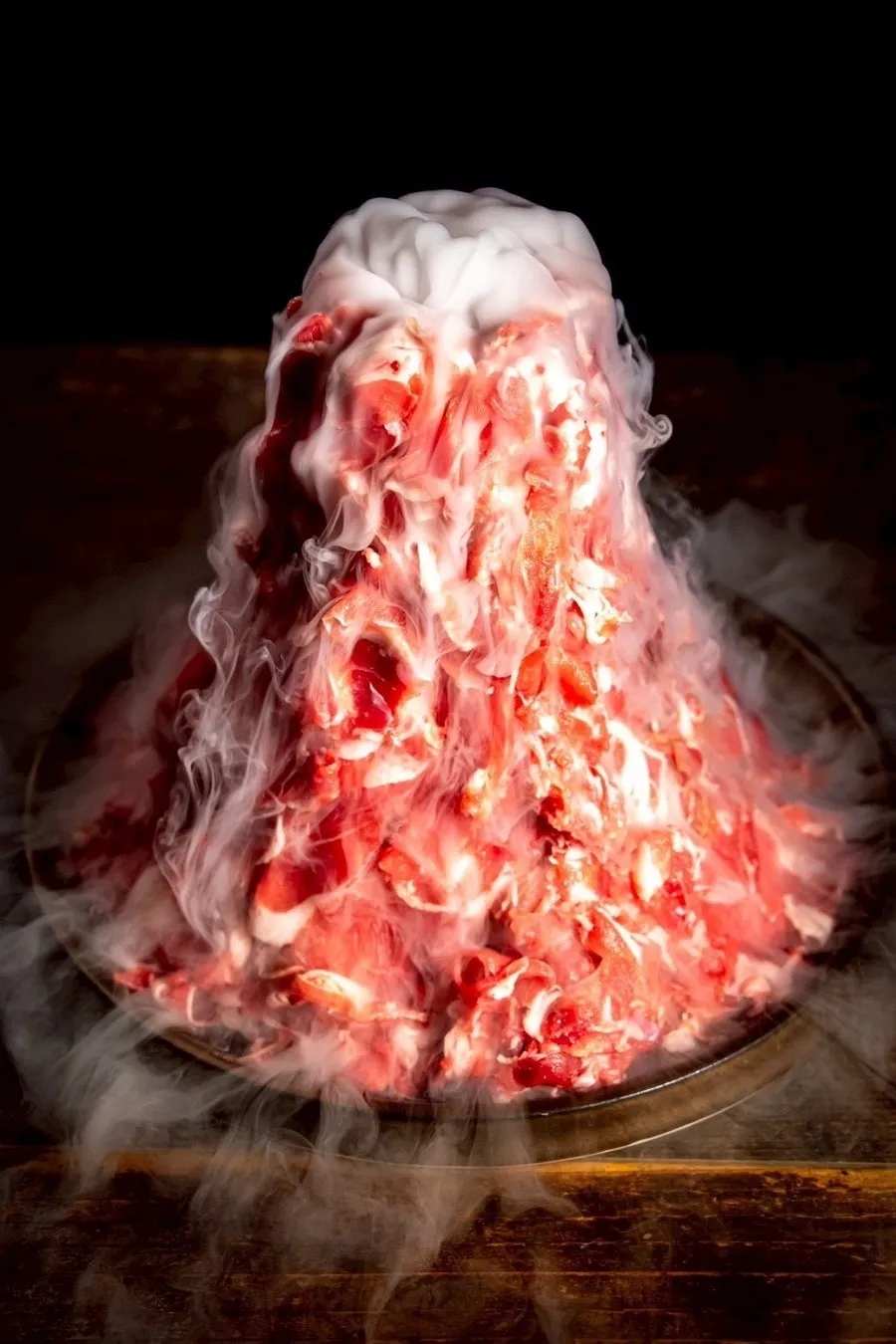 ドライアイスで演出された、肉の山盛りの料理