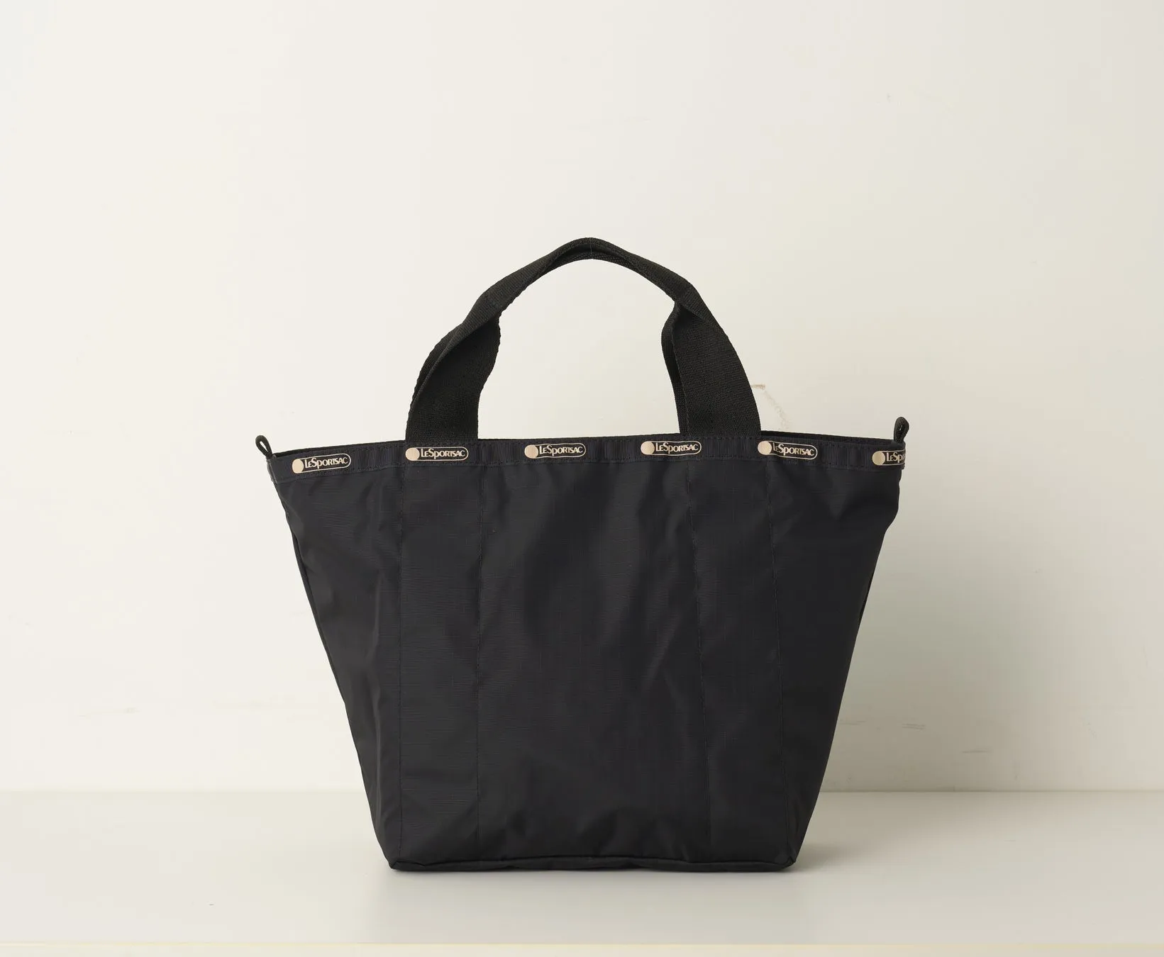 黒いトートバッグが白い背景に置かれています。