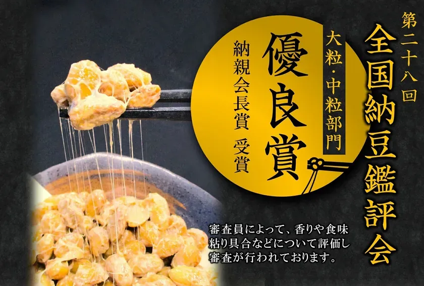 納豆の写真で、箸で持ち上げられた納豆と、器に入った納豆が写っています。背景には、全国納豆鑑評会のロゴと文字が書かれています。