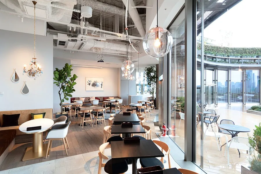 開放感のあるカフェの店内。窓から見える都会の景色が特徴的。