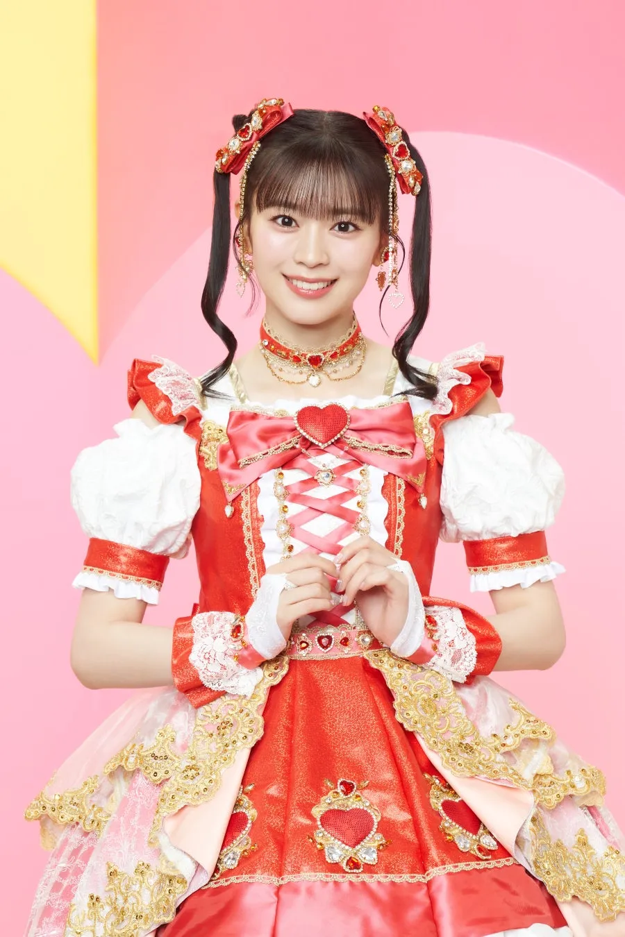 ケーキを食べる女性の写真。赤いマフラーとセーターを着ており、ケーキをフォークで口に運んでいる。