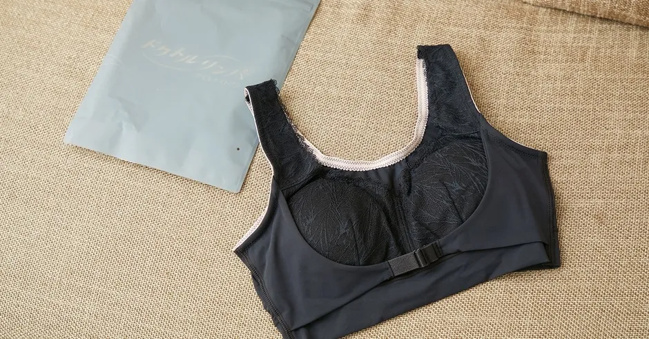 黒いブラジャーが写った写真。ブラジャーはレースが施されており、パッドが入っている。ブラジャーの横には、ロゴが入った袋が置かれている。