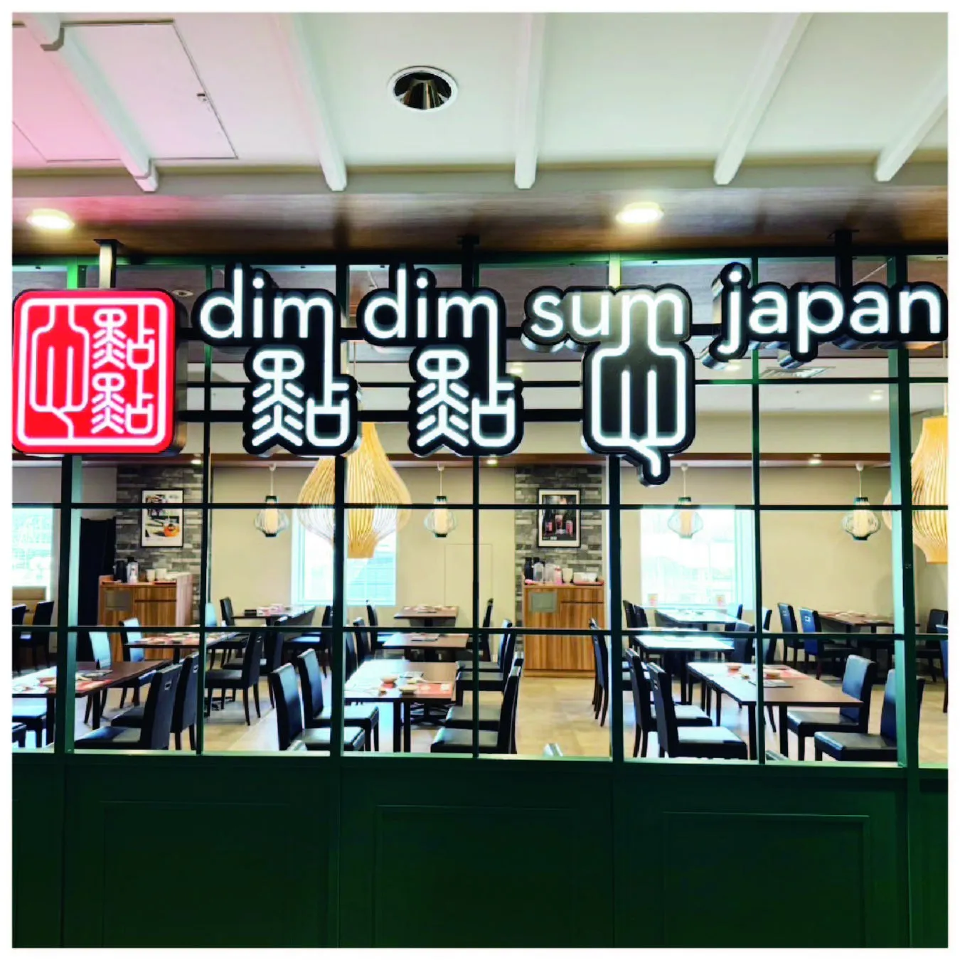 レストランの入り口の画像。看板には「dim dim sum japan」と書かれており、店内にはテーブルと椅子が並んでいます。