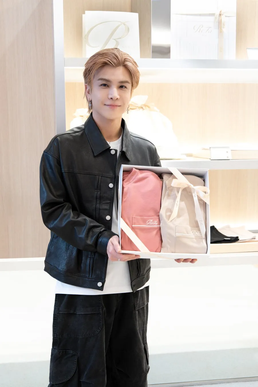 男性がReFaのギフトボックスを持って微笑んでいる写真。