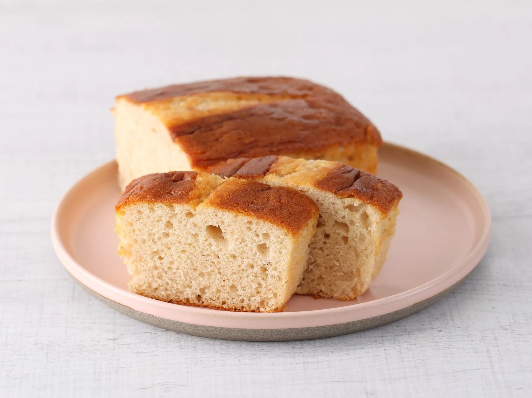 ピンクの皿に載った、カットされたパンのクローズアップ写真。