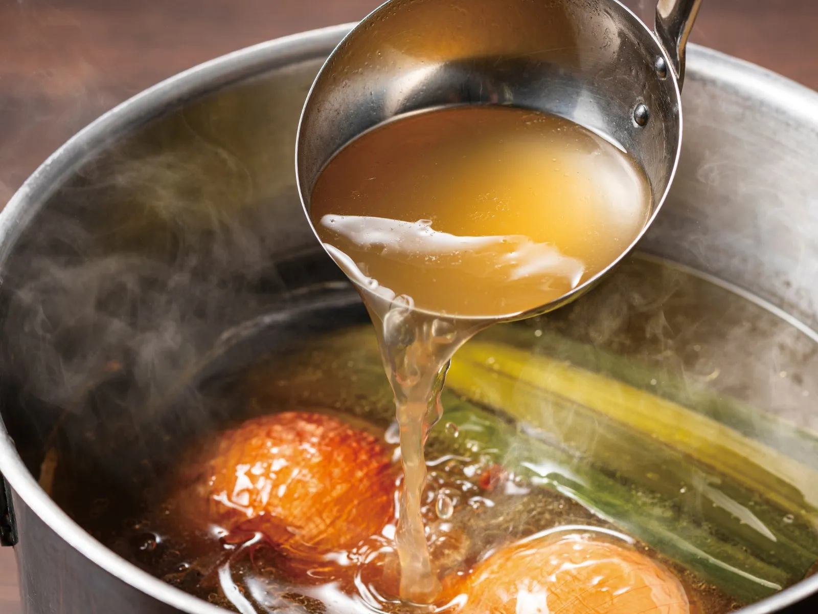 鍋からお玉でスープを注いでいる様子