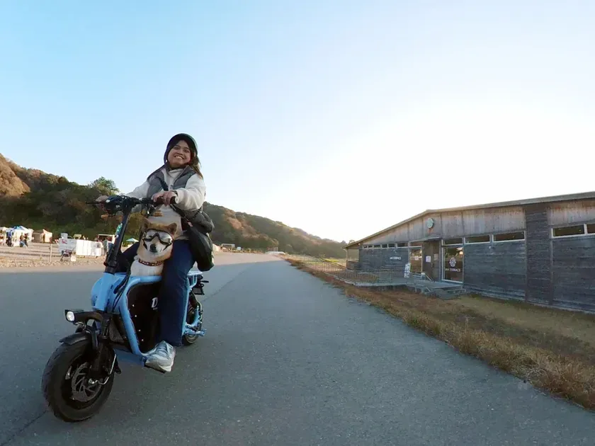 電動バイクに乗った女性と犬