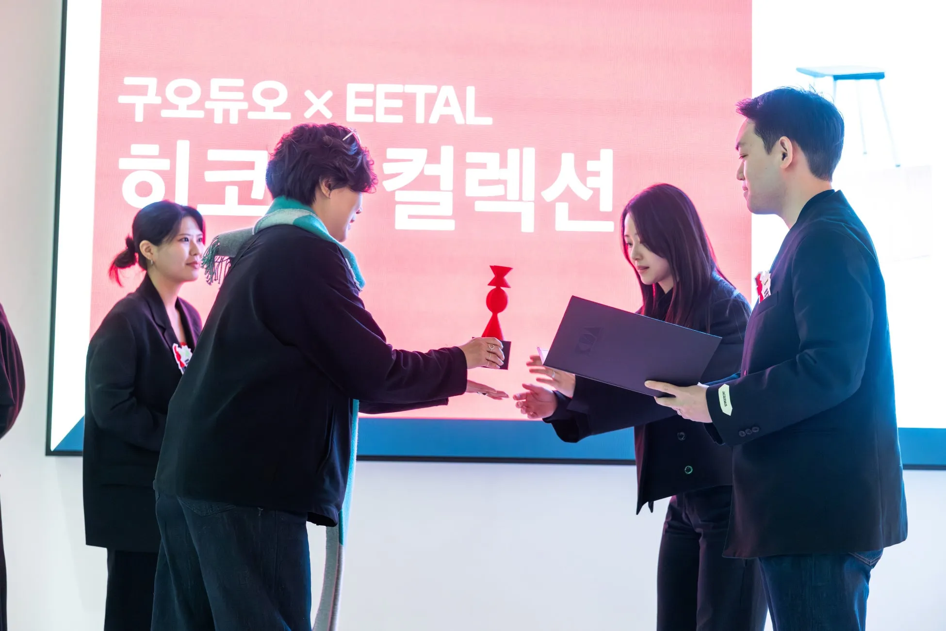 プレゼンテーション中、トロフィーを交換する人々。