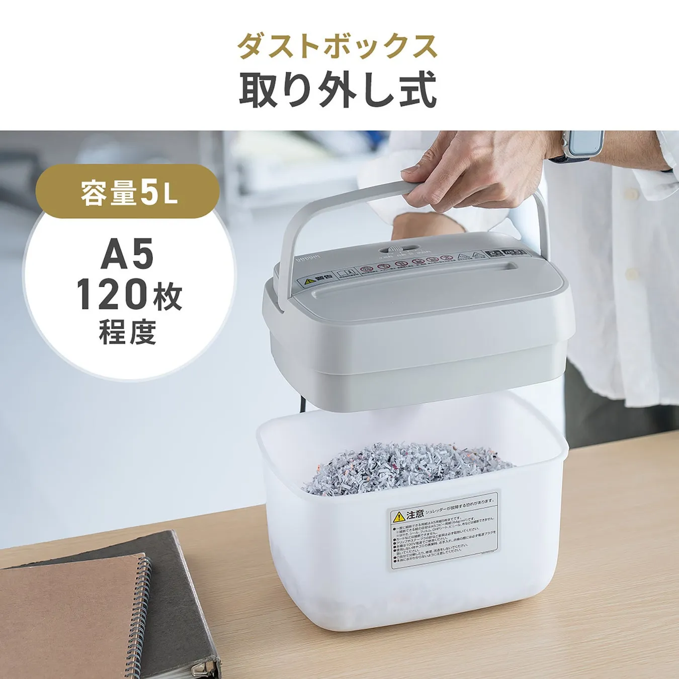 紙を細かく裁断できるシュレッダーの製品画像。ダストボックスを取り外す様子が写っており、容量や対応サイズ、枚数などが記載されている。