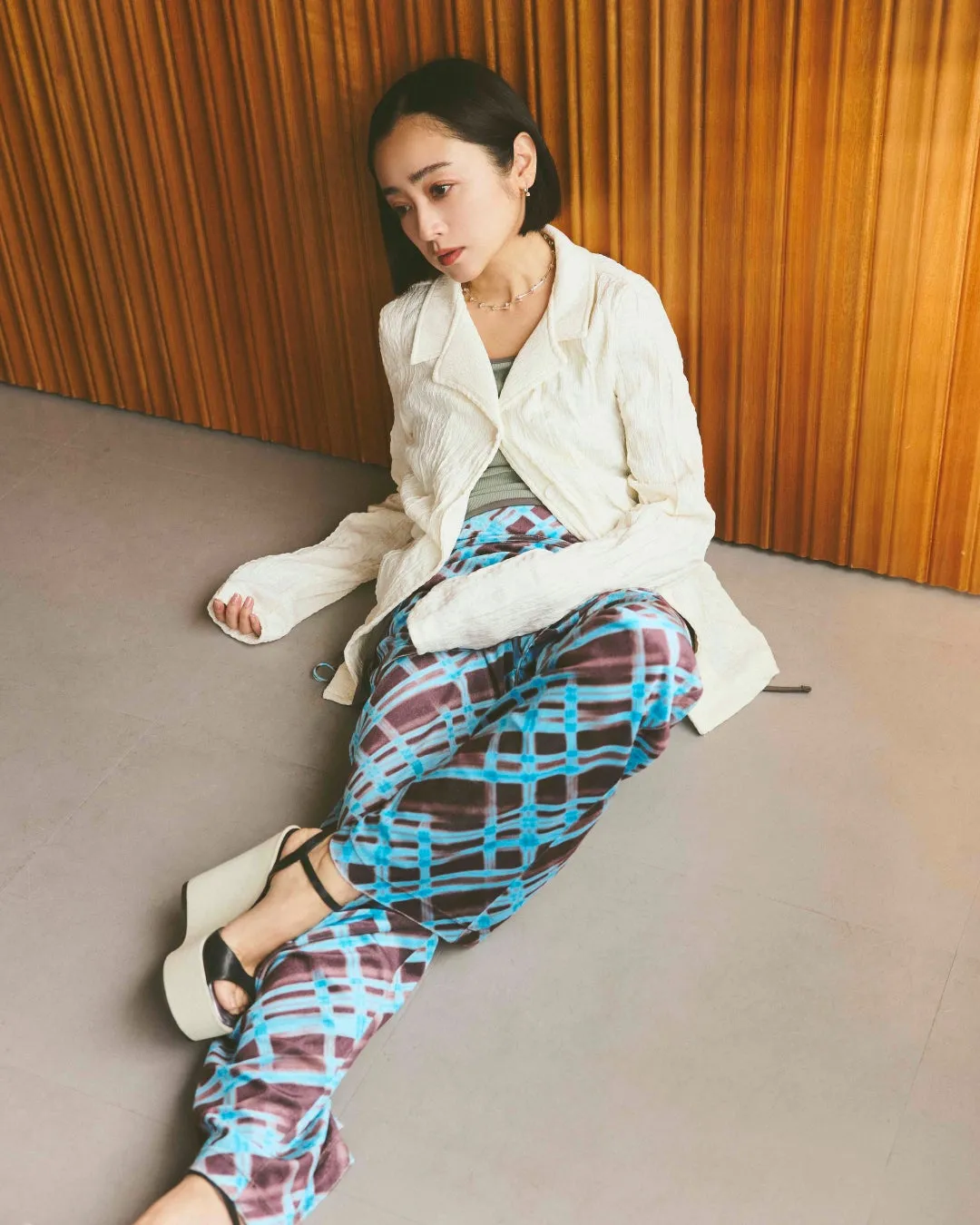 女性が床に座ってポーズをとるスタイリング