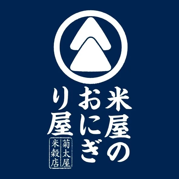 青色の背景に、白い文字とシンボルが描かれたロゴ。上部には三角形が2つ重なったシンボルがあり、その下に「米屋のおにぎり屋」と書かれています。さらにその下に「菊太屋米穀店」と書かれています。
