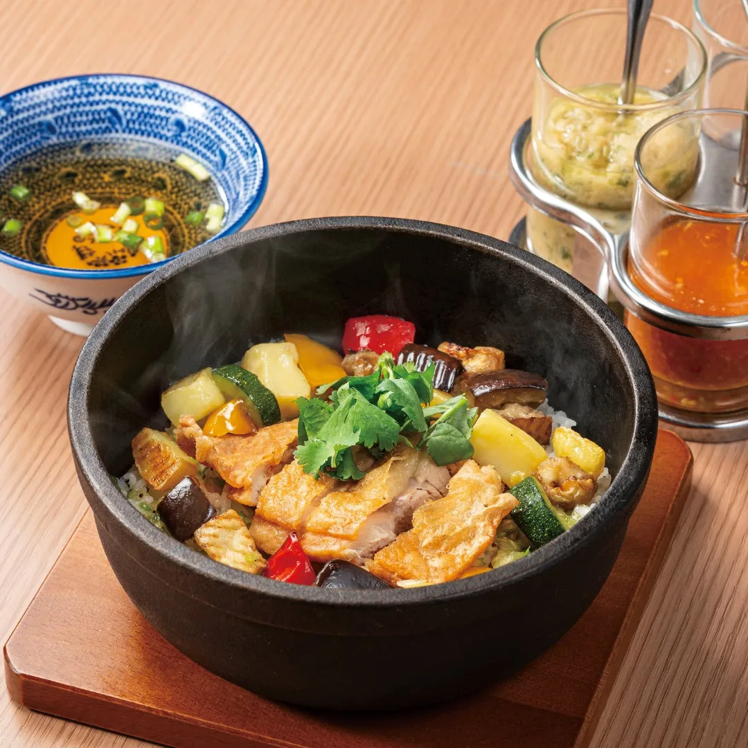 熱々の石鍋に入った炊き込みご飯とスープ、ソース