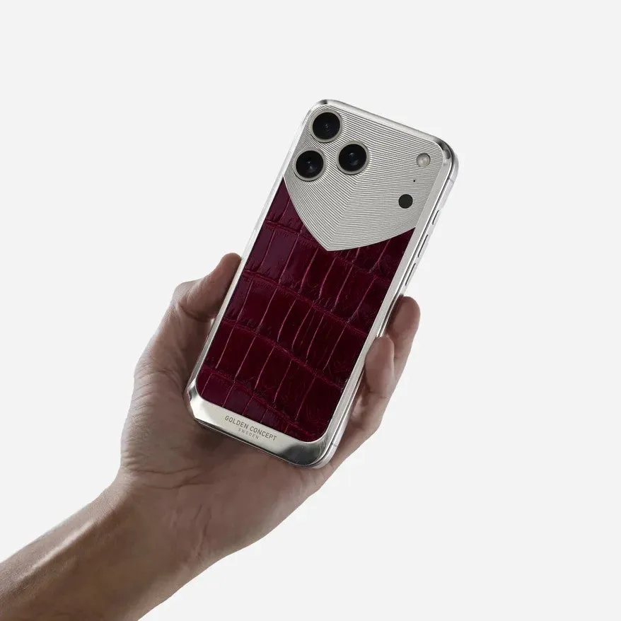 手で持たれた、赤い革のディテールと銀色のアクセントが施されたiPhoneケースのクローズアップ画像。