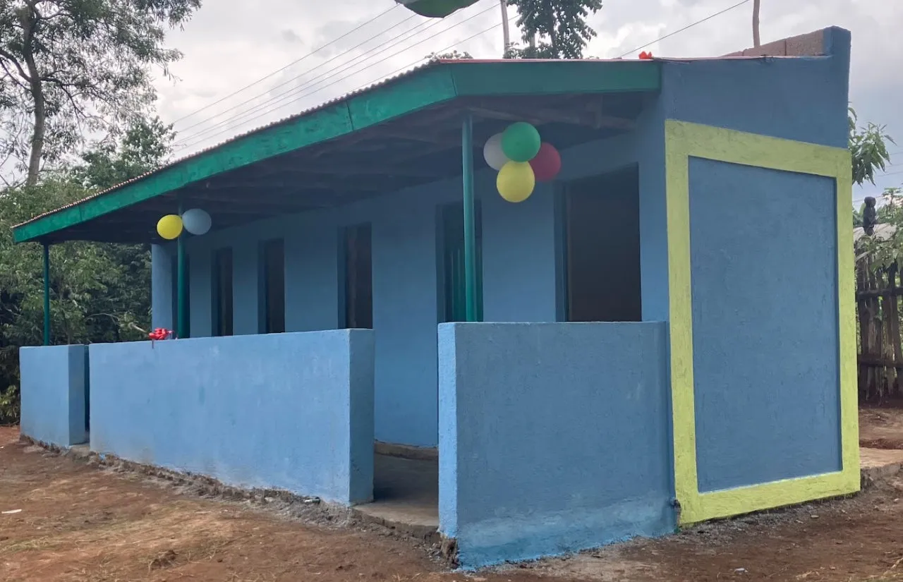 青い壁と緑の屋根を持つ建物で、風船で飾られています。