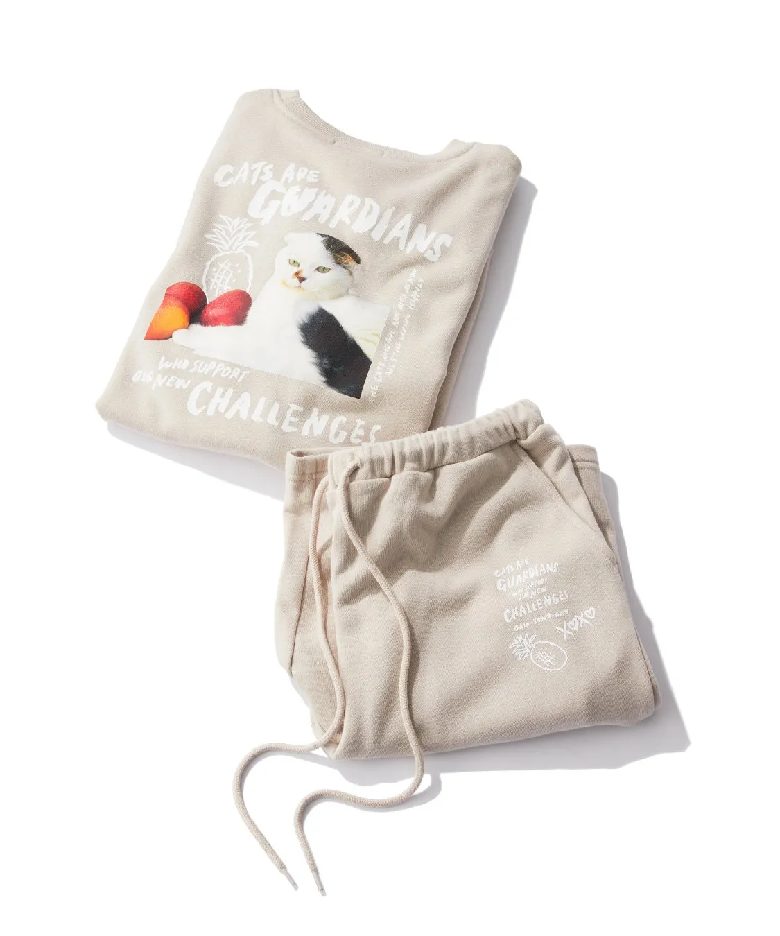 猫のイラストがプリントされた上下セットのベージュ色のスウェット