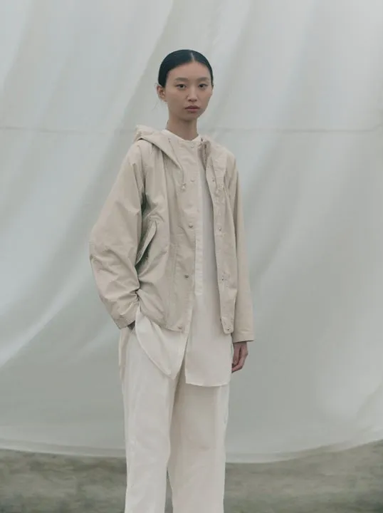 ベージュのフード付きジャケットを着た女性モデル