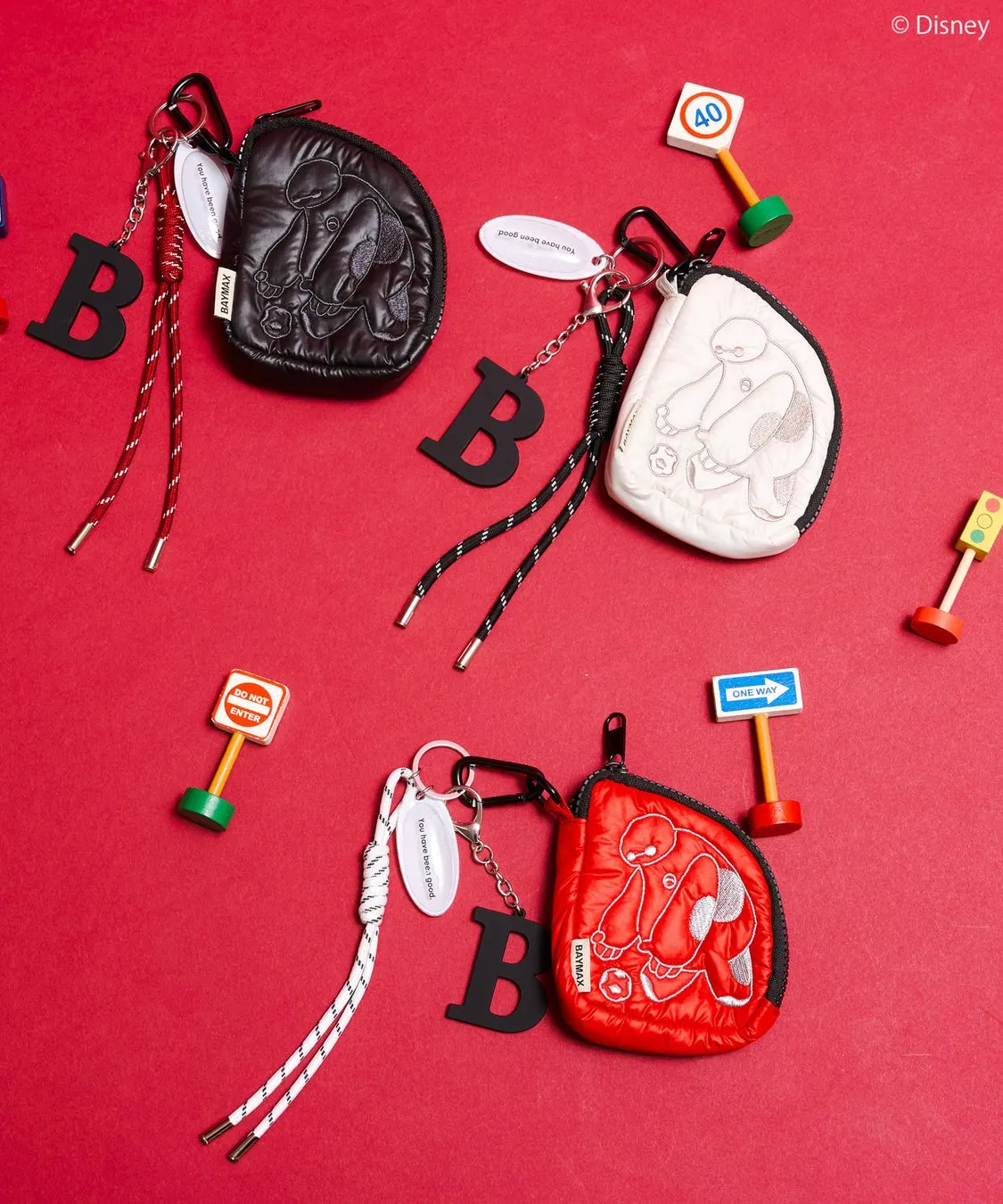 ベイマックスのキャラクターが描かれたポーチ、キーホルダー、オブジェが配置された画像