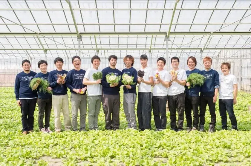 温室で野菜を持って立つさいたまヨーロッパ野菜研究会のメンバー