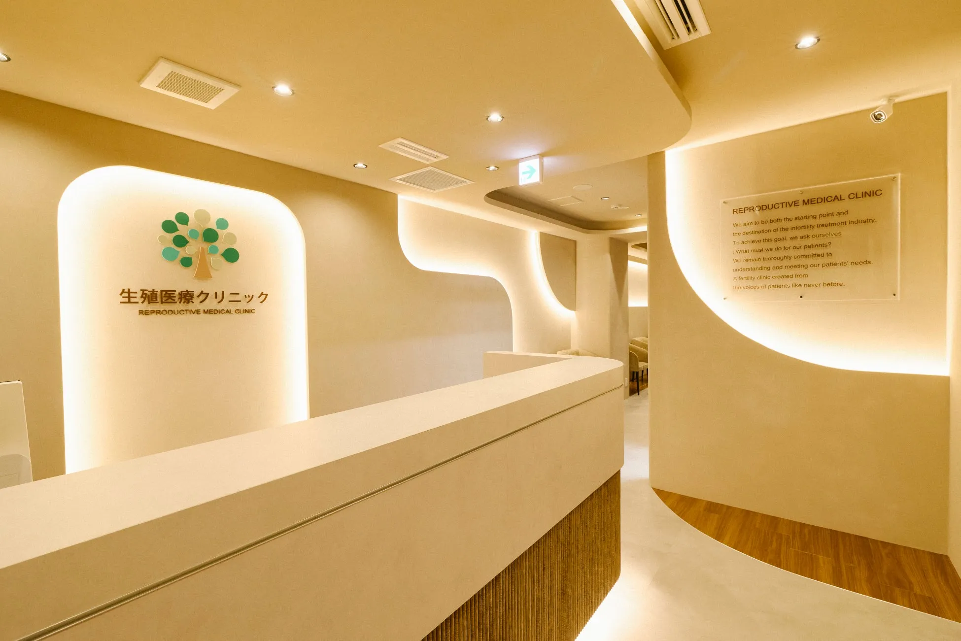 クリニックの受付の様子。白を基調とした内装で、壁にはロゴと標語が掲げられています。