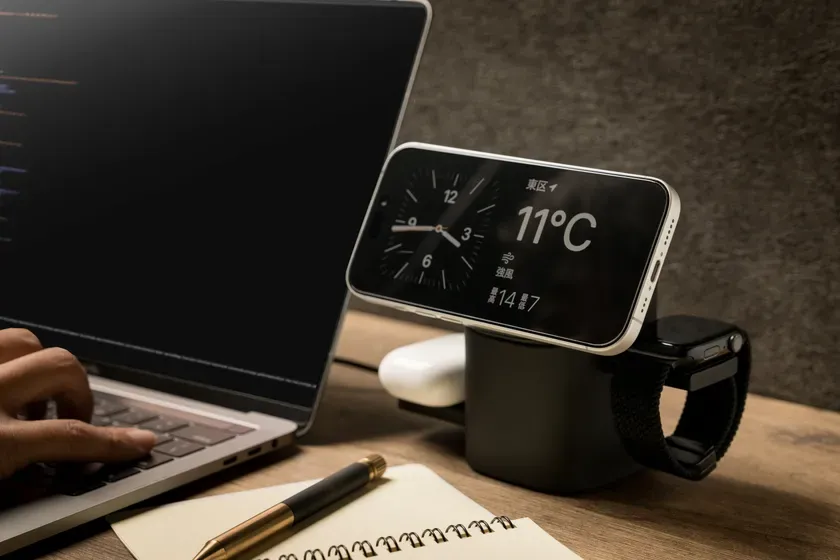 スマートフォン、Apple Watch、AirPods、ノートパソコン、ペンが写っている写真。スマートフォンには天気予報が表示されており、気温は11℃。