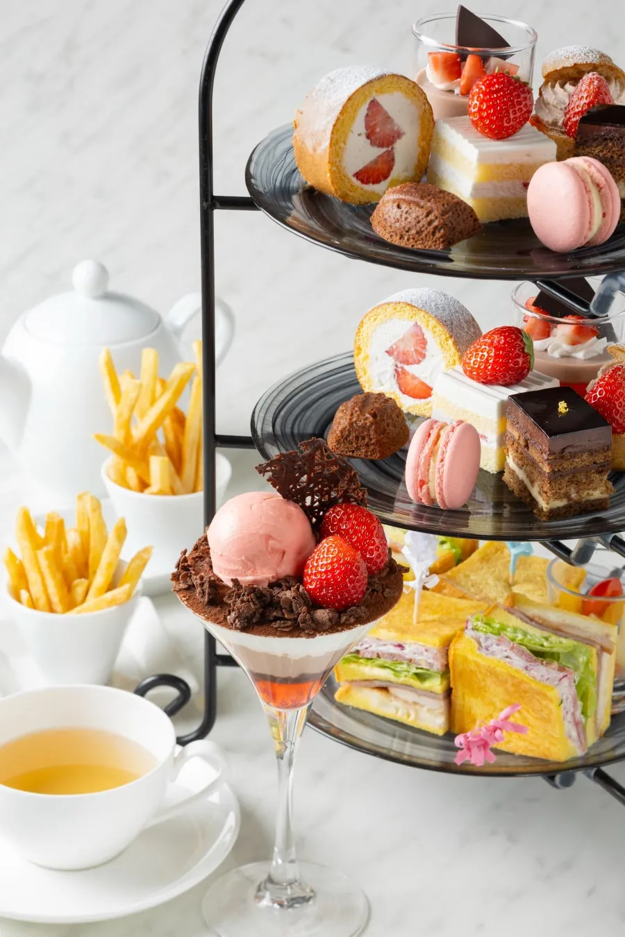 アフタヌーンティーセットの画像。3段のケーキスタンドには、様々な種類のデザートが並べられています。
