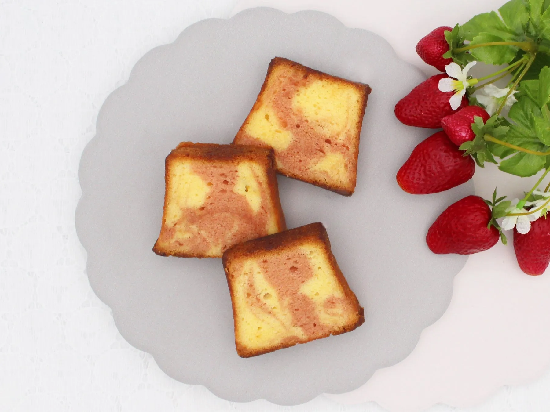 ケーキとイチゴが写った写真です。ケーキはマーブル模様で、イチゴと一緒に盛り付けられています。