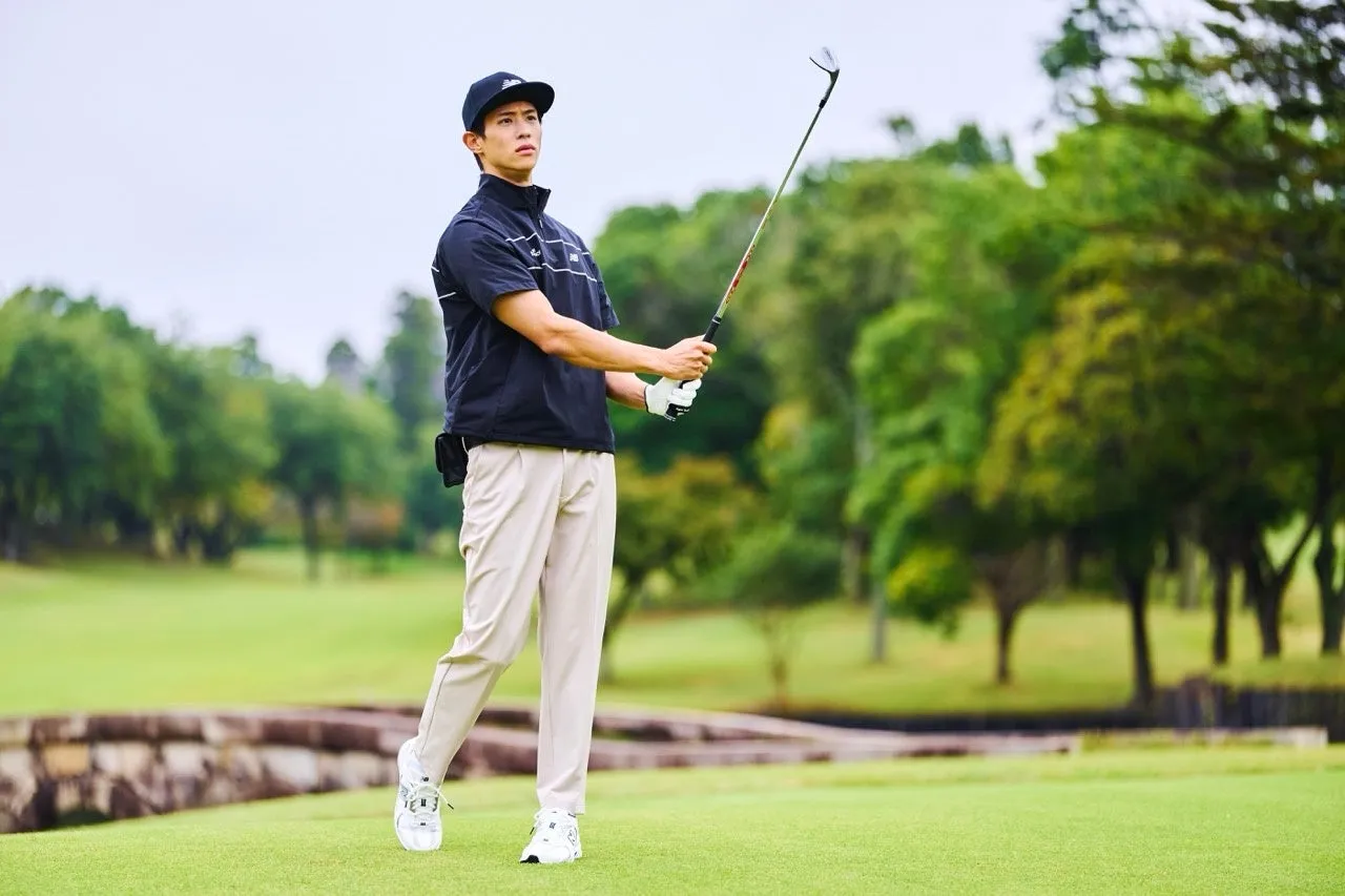 ゴルフ場でゴルフのスイングをする男性。