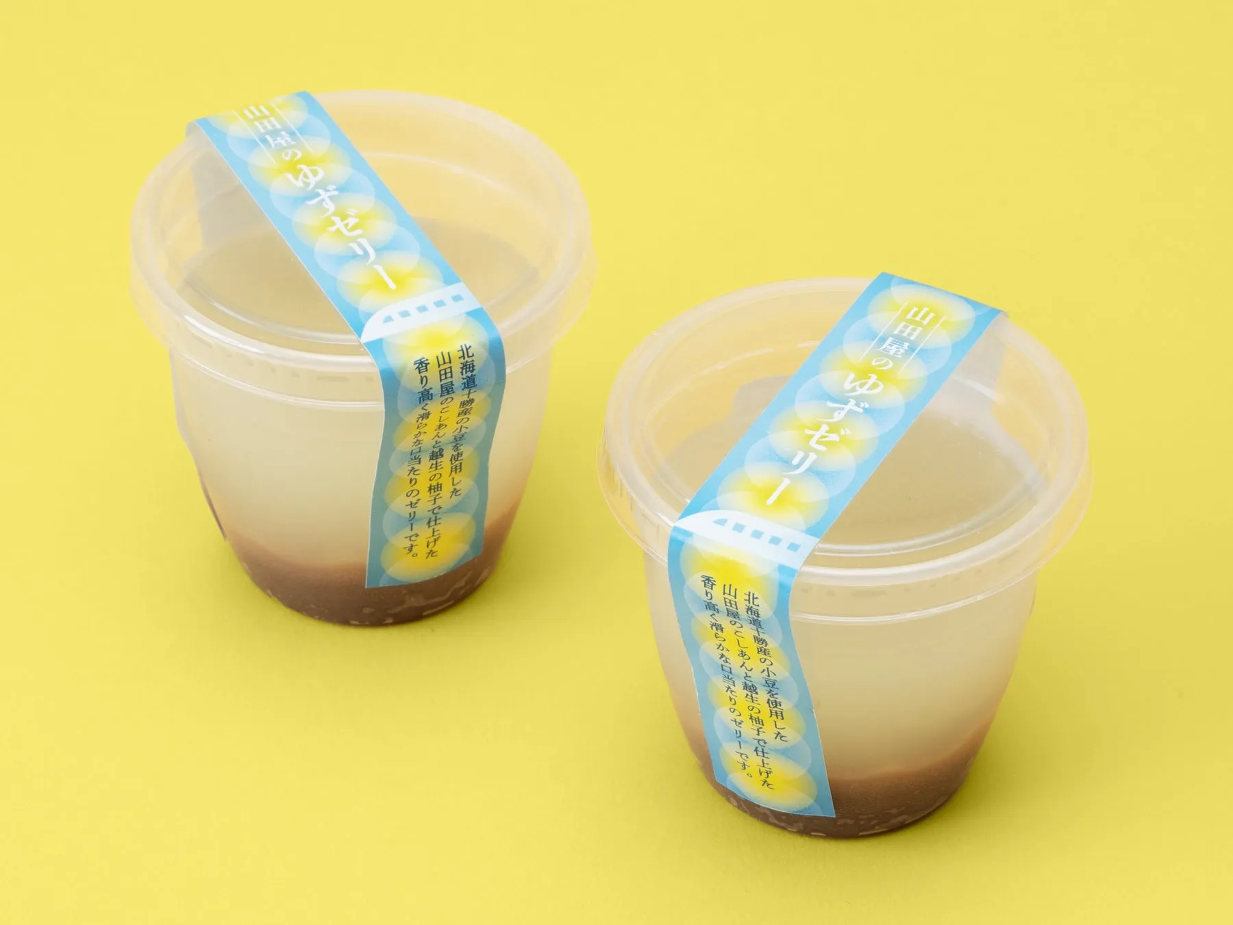 2つのゆずゼリーが入ったプラスチック容器の写真。ラベルには「山田屋のゆずゼリー」と書かれており、その下には商品の説明が書かれています。
