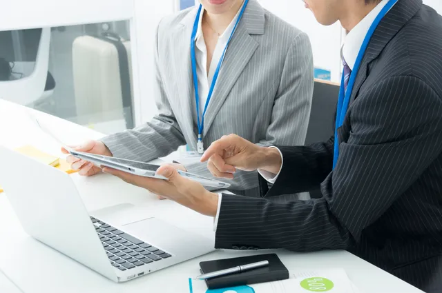 オフィスでタブレットを見ながら打ち合わせをしている様子