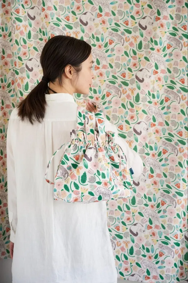 女性が花柄のバッグを持っている