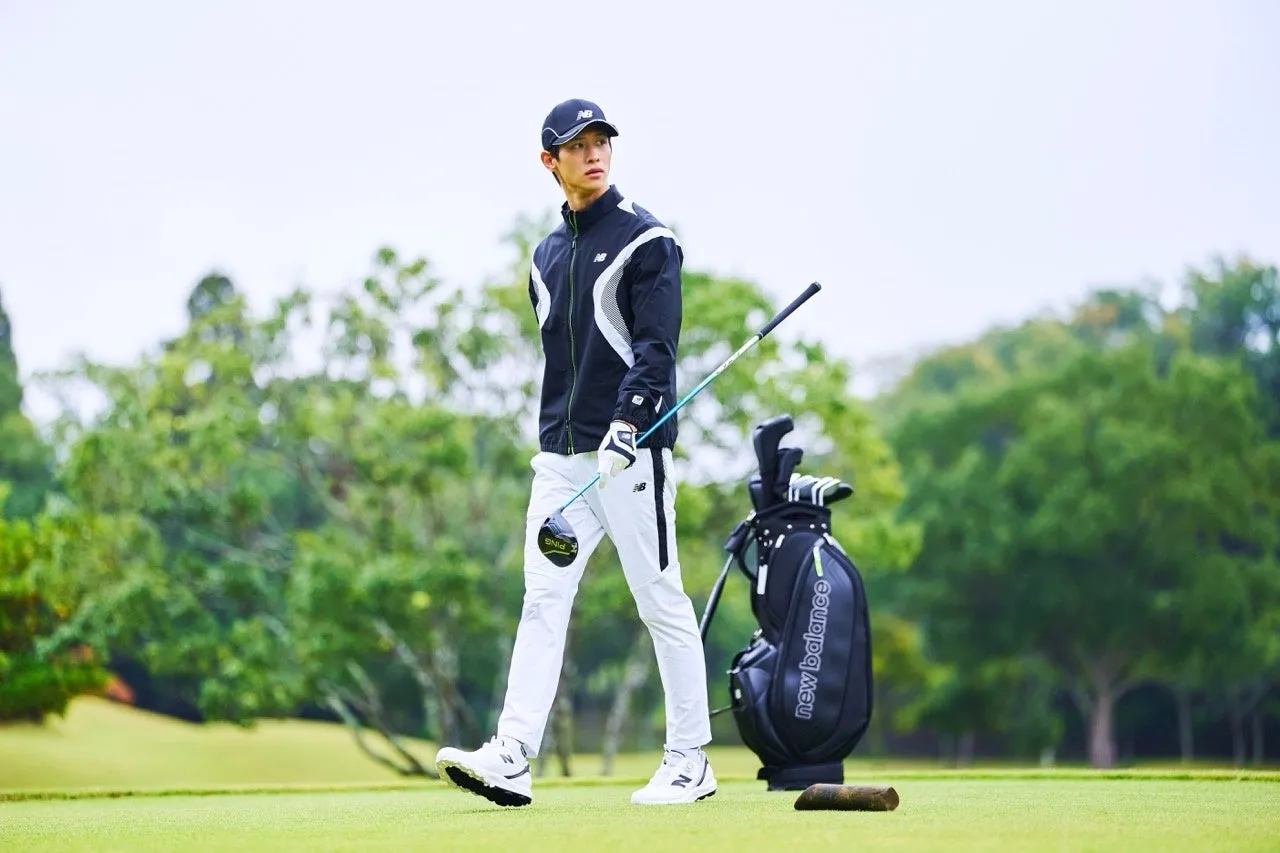 ゴルフウェアを着てゴルフコースを歩く男性。