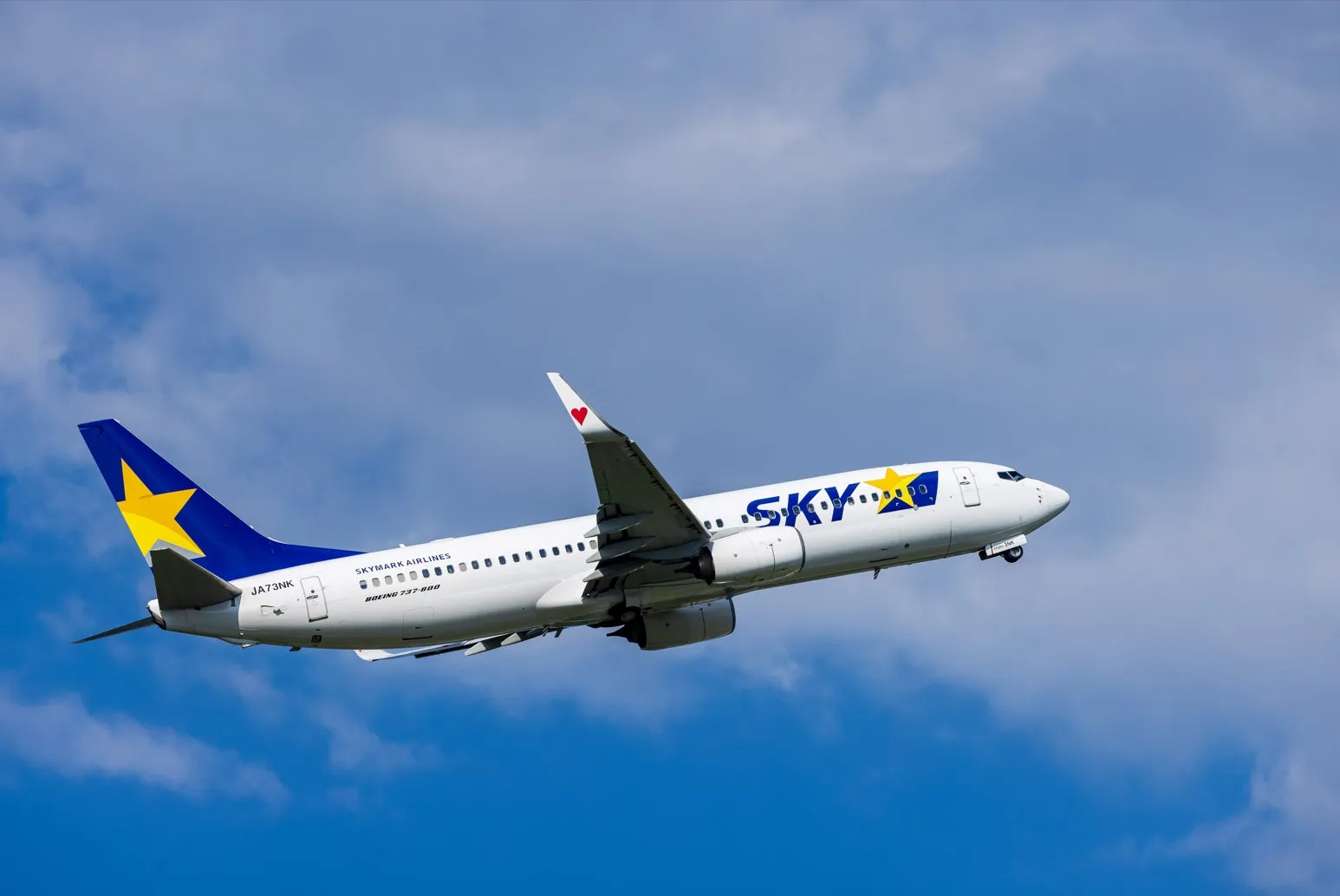 青空の下、離陸するスカイマークのボーイング737-800型旅客機の写真。